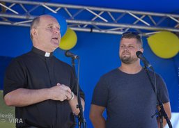 Otec Jan Larisch vítá návštěvníky festivalu po boku moderátora