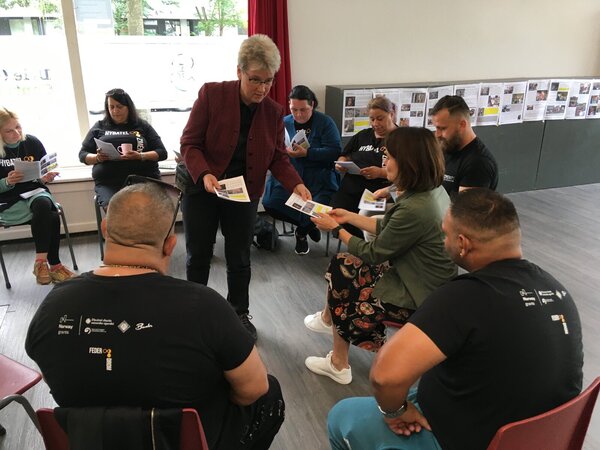 Dobrovolnice Karla předává lídrům podklady k workshopu